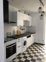 a kitchen with white cabinets and a washing machine at La Tanatte de wimereux sur la côte d opale in Wimereux