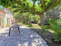 a bench sitting on the ground under a tree at mas cantarello in Rognes