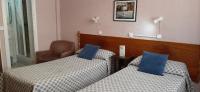 A bed or beds in a room at Hostal San Martin