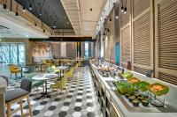 een restaurant met een buffet met tafels en stoelen bij URBAN Al Khoory Hotel in Dubai