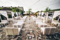 een rij witte stoelen en parasols op een patio bij Wioska Rybacka Wilga in Wilga
