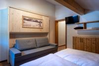 a bedroom with a bed and a couch and a tv at CHALET MONTIS in Flachau