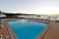 a large swimming pool with a view of the ocean at Hotel Tettola in Saint-Florent