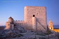 a large brick building with a tower on a hill at Complejo Pueblo Blanco in Olvera