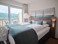 a bedroom with two beds and a large window at SEE Moment Appartements ADULTS ONLY in St. Wolfgang