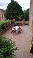 a patio with a table and benches on a brick patio at Les Hauts de Proisy in Proisy