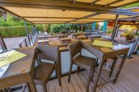 a patio with tables and chairs on a deck at Hotel Freiensteinerhof Superior in Sankt Peter-Freienstein