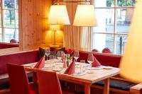 einen Tisch in einem Restaurant mit roten Servietten und Weingläsern in der Unterkunft Hotel Riezler Hof in Riezlern