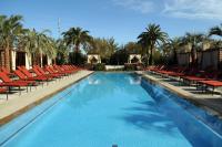 einen großen Pool mit roten Stühlen und Palmen in der Unterkunft M Resort Spa &amp; Casino in Las Vegas