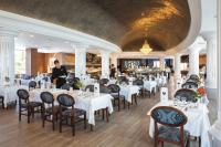 アデへにあるHotel Riu Palace Tenerifeの白いテーブルと椅子のあるダイニングルーム
