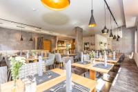 ザールバッハ・ヒンターグレムにあるHotel Almrauschの木製のテーブルと椅子のあるダイニングルーム