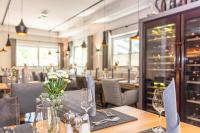 ザールバッハ・ヒンターグレムにあるHotel Almrauschのワイングラスが置かれたテーブルのあるダイニングルーム