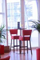 een tafel en stoelen in een kamer met een raam bij Ramada Encore By Wyndham Tangier in Tanger