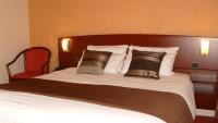 a large bed with two pillows on top of it at Cit&#39;Hotel Saint Jacques in Parthenay