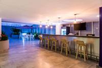 un bar con taburetes de madera en una habitación en La Quinta by Wyndham Medellin, en Medellín