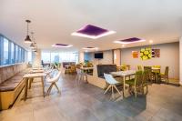Un restaurante con mesas y sillas en una sala. en La Quinta by Wyndham Medellin, en Medellín