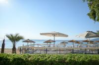 grupa stołów i parasoli na plaży w obiekcie Seasabelle Hotel near Athens Airport w mieście Artemida