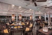 a restaurant with tables and chairs and a ceiling fan at GYP SEA Saint Barth in Gustavia