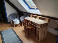 a room with a wooden desk and chairs in a attic at Gite les Bruyères in Salbris