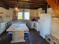 a kitchen with a table and a white refrigerator at Gite les Bruyères in Salbris