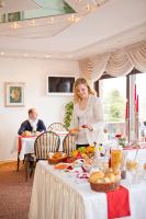 a woman standing in front of a table with food at Pension Gimpel in Bad Wildungen