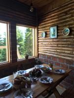 Una mesa de madera con comida en una habitación con ventanas. en Guest House Golijski Dar, en Dajići