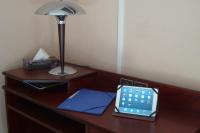 a desk with a lamp and a calculator on it at Cit&#39;Hotel Saint Jacques in Parthenay