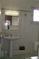 a white bathroom with a sink and a mirror at Cit&#39;Hotel Saint Jacques in Parthenay