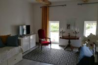 a living room with a bed and a table and a chair at Les écuries du chateau in Commes