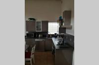 a kitchen with a black cat on top of the cabinets at Les écuries du chateau in Commes