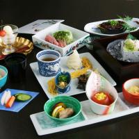 a table topped with different types of food on plates at Kitabiwako Hotel Grazie in Nagahama