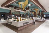 Un chef de pie frente a un buffet en un restaurante. en Hotel Riu Cabo Verde - Adults Only - All Inclusive, en Santa Maria