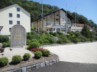 Un edificio y un monumento delante de un edificio. en Hotel Burgwirt, en Deggendorf