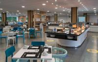 Un restaurante con mesas y sillas y una cafetería. en Medplaya Hotel Regente, en Benidorm