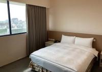 a hotel room with a bed and a large window at Shun-yi Business Hotel in Chiayi City