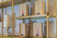 a shelf with books and a candle on a table at The Melegran in Rovinj