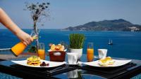 a table with plates of food and a person pouring juice at Amari Phuket in Patong Beach