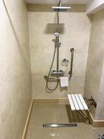 a bathroom with a shower with a bench in it at Hotel Arnia in Iaşi