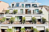 an apartment building with a balcony with tables and chairs at ART HOUSE Basel - Member of Design Hotels in Basel