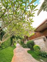 a brick walkway in front of a house with a tree at Yage Hotspring House in Jiaoxi