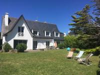 a white house with lawn chairs in the yard at Holiday Home Maison Courlis by Interhome in Carnac