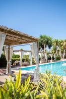 a pool at a resort with white umbrellas and palm trees at Can Jaume by Ocean Drive in Ibiza Town