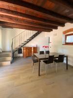 a dining room with a table and chairs and a staircase at Villa Broglia House in Verona