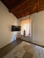a bedroom with a bed and a chair and a window at Villa Broglia House in Verona