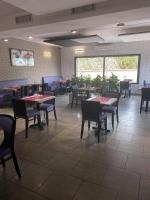 een eetkamer met tafels en stoelen in een restaurant bij Hotel Restaurant Vesontio in Besançon