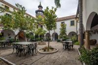a courtyard with tables and chairs and a tower at La Almoraima Hotel in Castellar de la Frontera