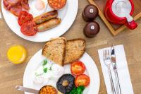 two white plates of breakfast food on a table at The Plume of Feathers in Mitchell