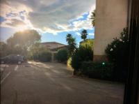 a car parked in a parking lot with the sun shining at Résidence mayflower in Le Grau-du-Roi