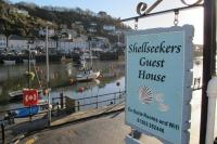 a sign for a guest house next to a marina at Shellseekers Guest House in Looe
