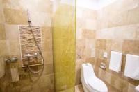 a bathroom with a toilet and a glass shower at MSR Port Hotel in Mangalia
